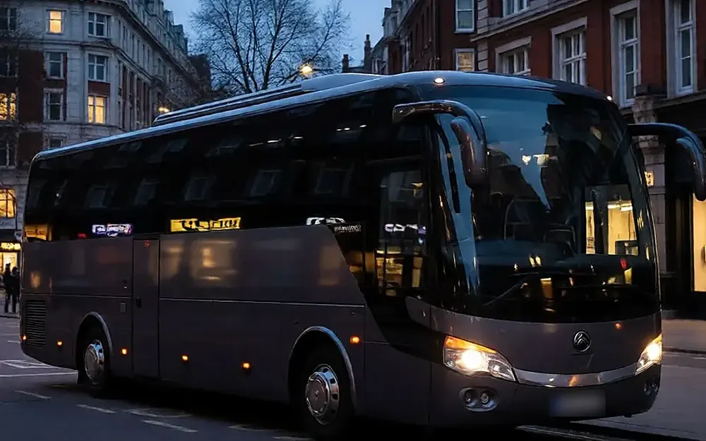 Dark grey 34-seat mini coach on a London street at dusk