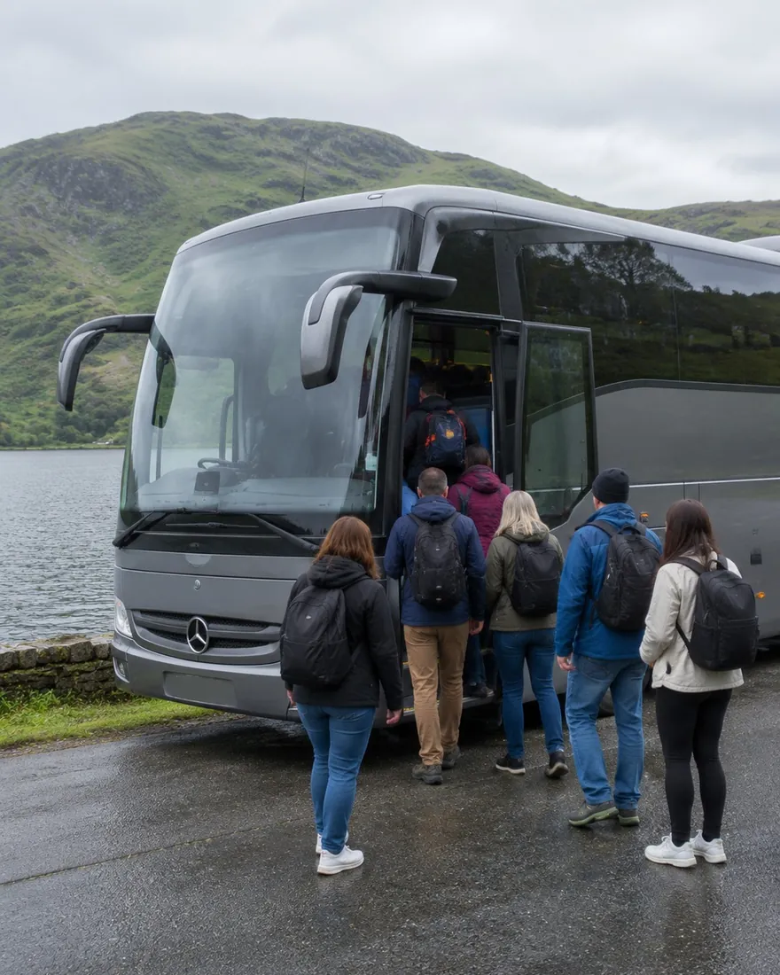 Group of passengers boarding a Mercedes coach beside a mountain lake