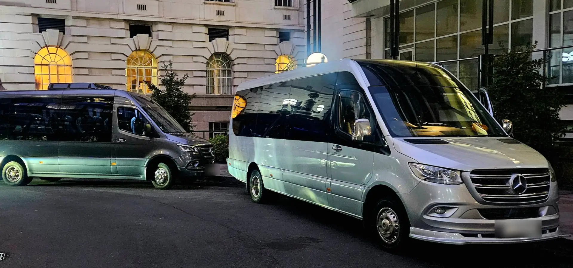 Two executive Mercedes minibuses parked outside a London hotel in the evening